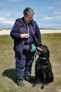 Lorna looking down lovingly at her previous dog, a black Labrador called Sam.